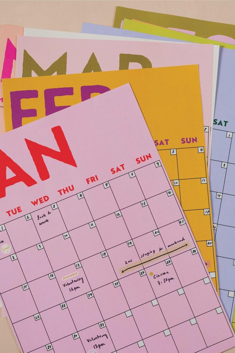 Colorful calendar sheets with different months on a light brown background