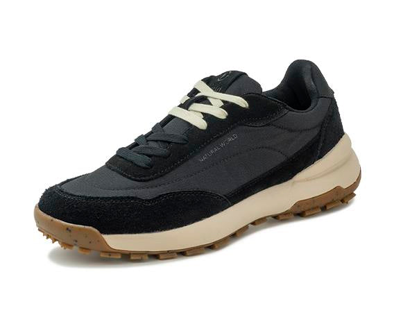 A black suede and mesh sneaker with off-white laces and a thick cream-colored midsole, shown from a side profile on a white background.