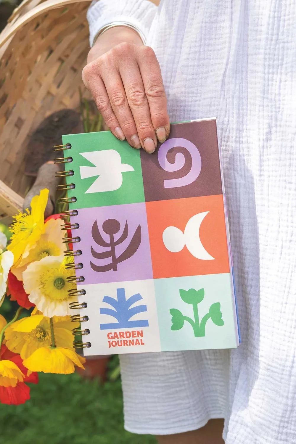 Person holding a colourful garden journal with floral decorations.