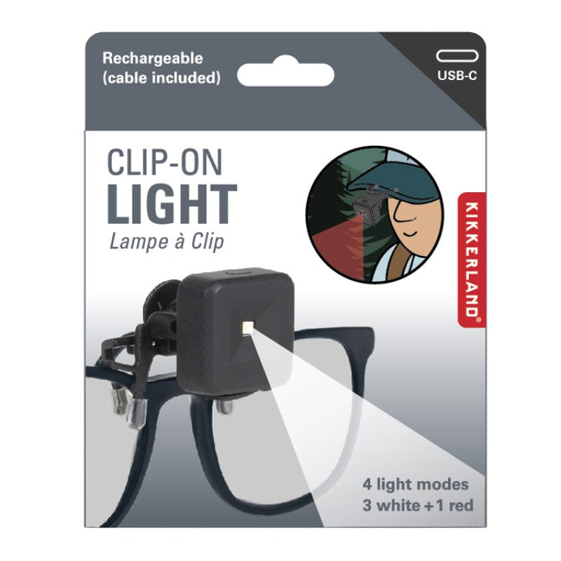 Kikkerland clip-on light packaging with a person using the light in the corner.