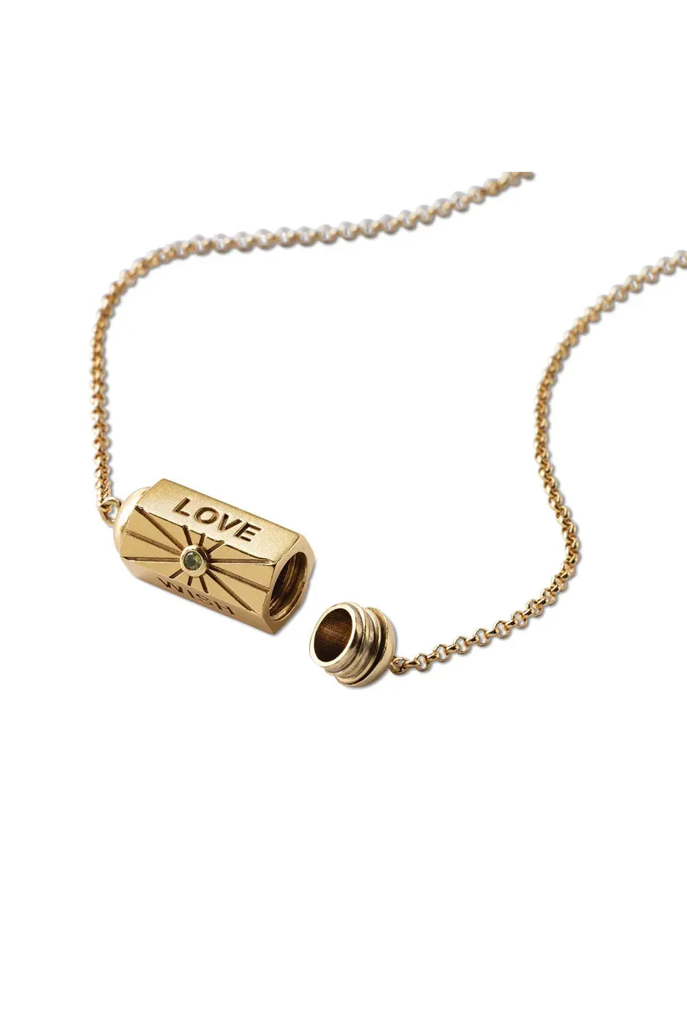 Gold necklace with cylindrical pendant on a white background