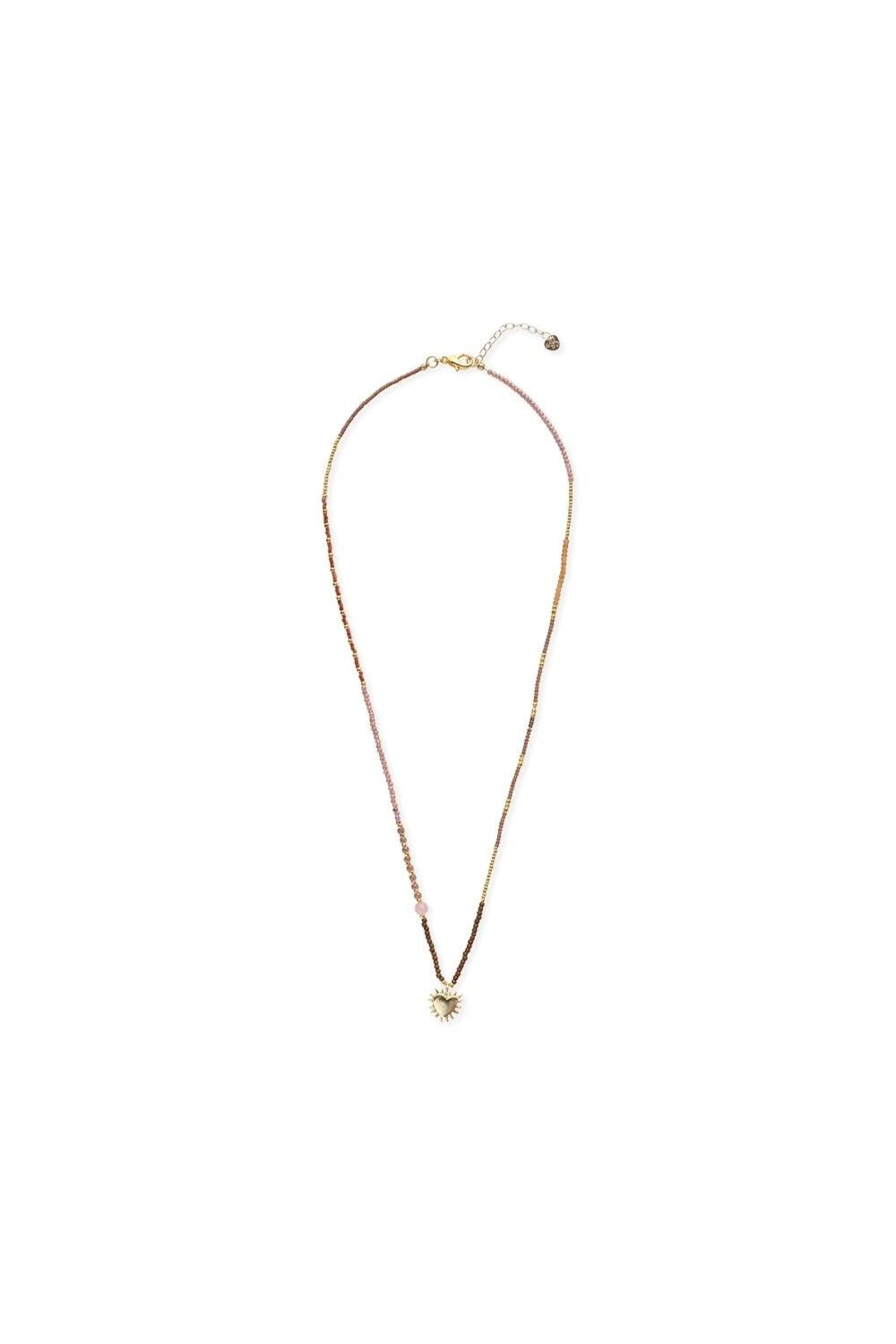 A delicate beaded necklace with a gold-tone chain, pink and gold beads, and a small gold sunburst pendant, displayed on a clean white background.
