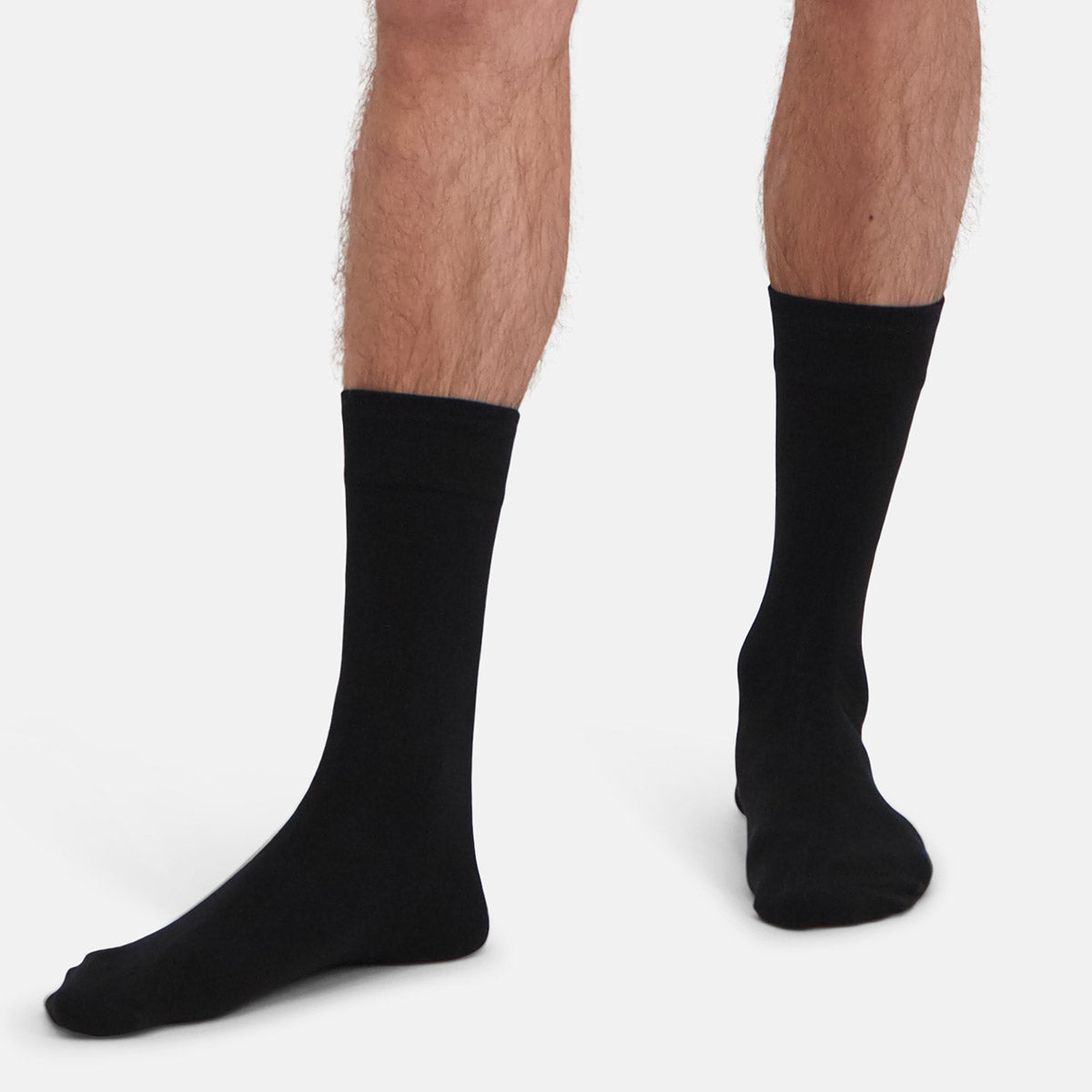 Black bamboo socks worn by a person on a white background