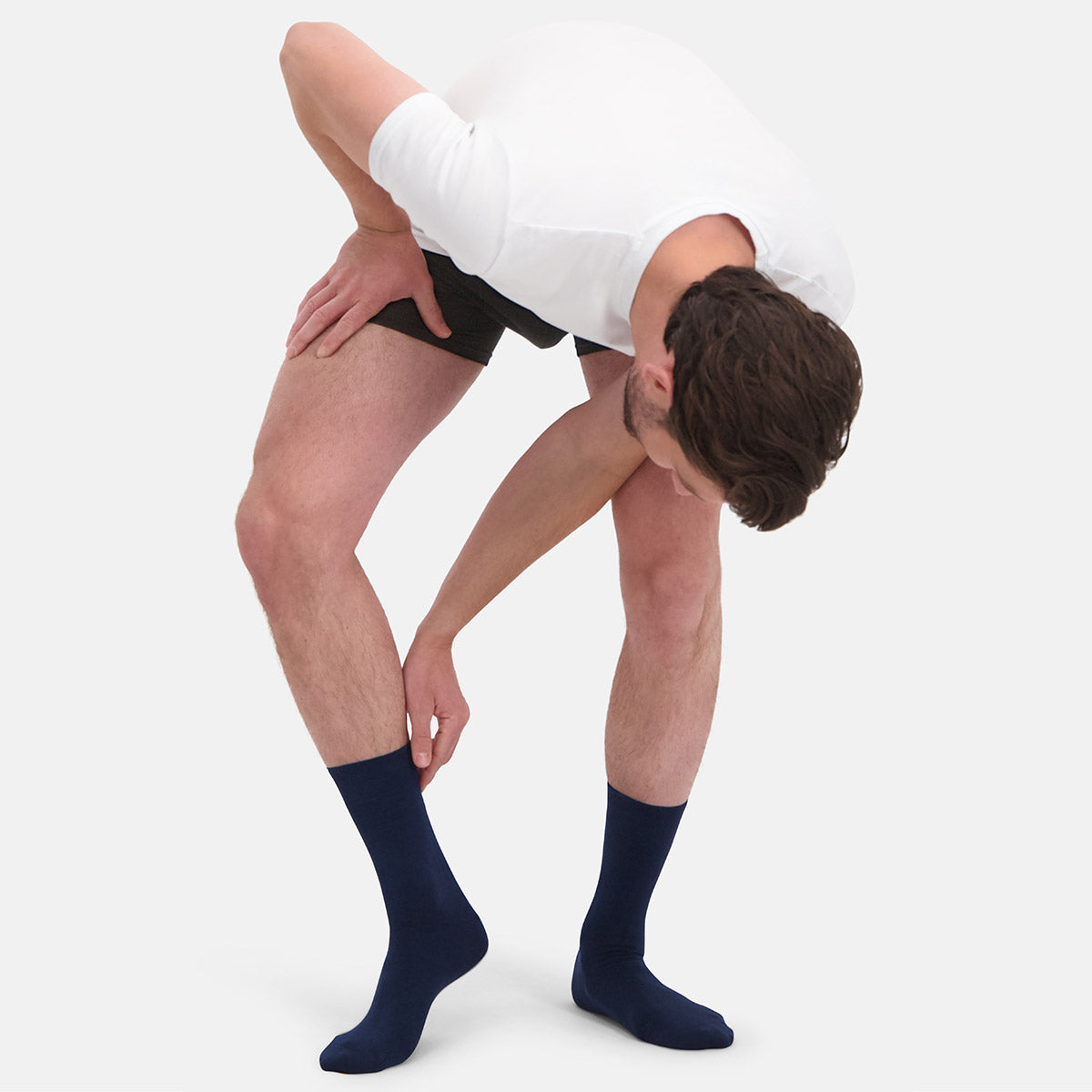 Person wearing navy bamboo socks on a white background