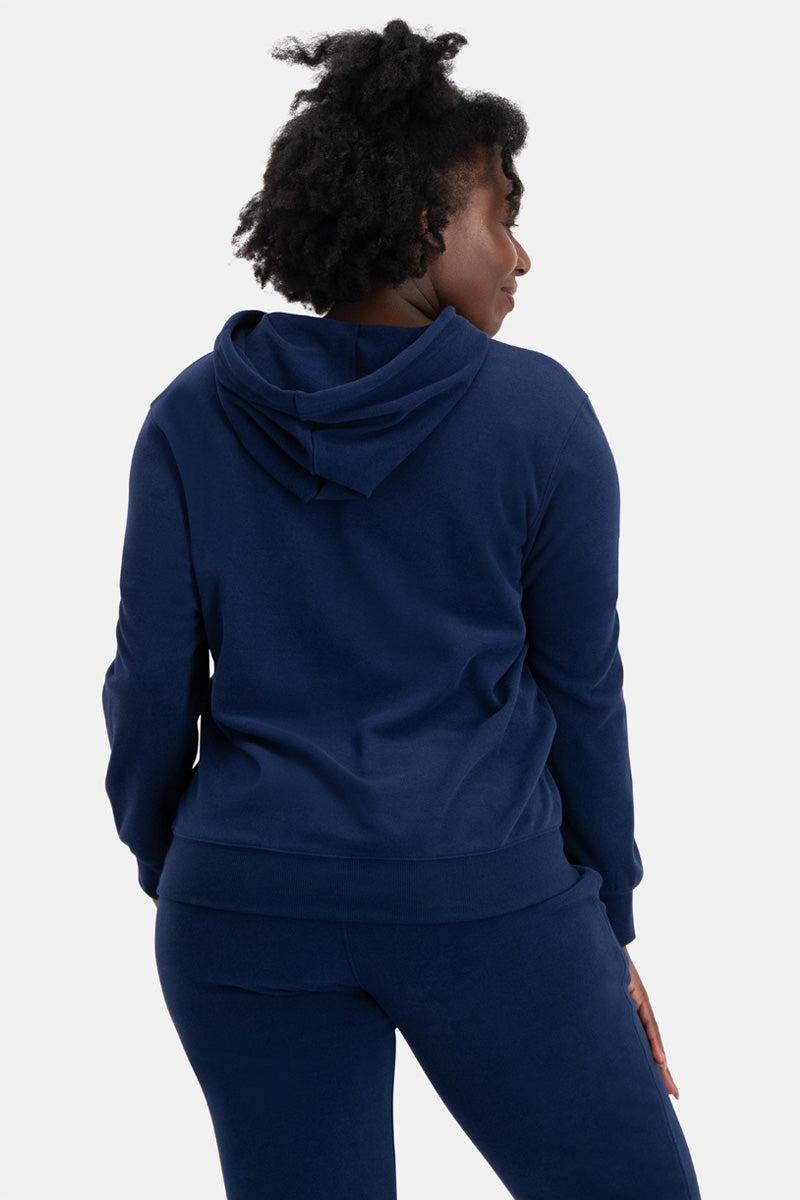 Person wearing a navy blue hoodie and pants on a white background