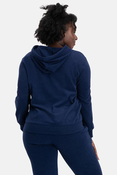 Person wearing a navy blue hoodie and pants on a white background