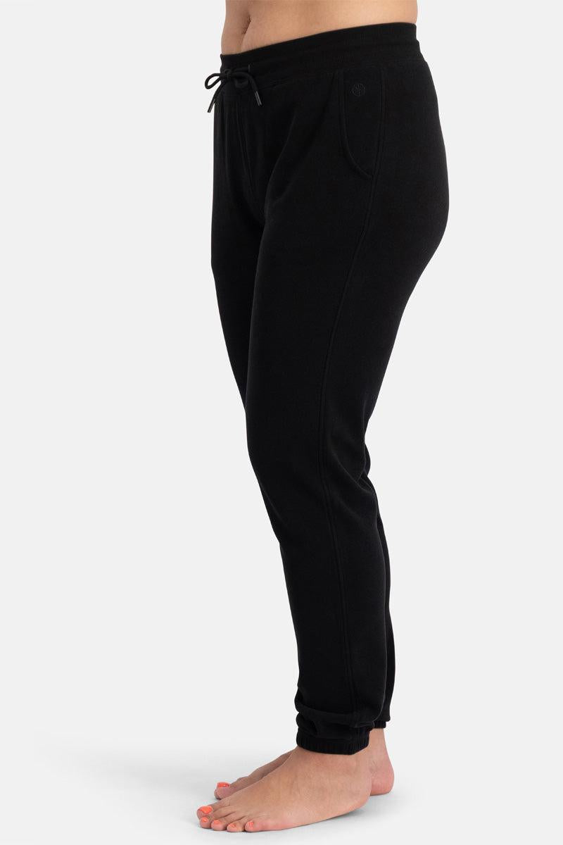 Black organic cotton jogger pants worn by a person on a white background