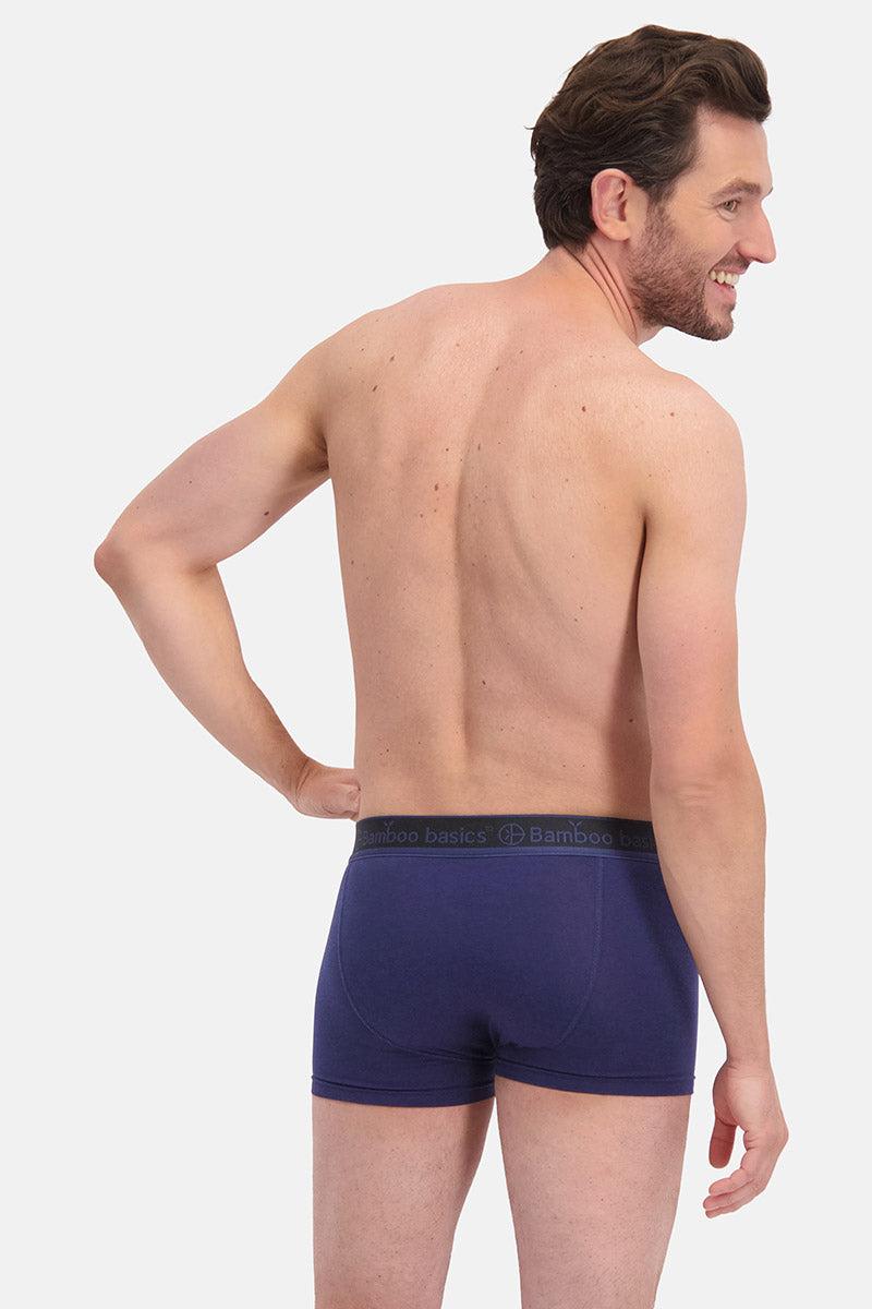 Man wearing navy blue boxer briefs on a white background