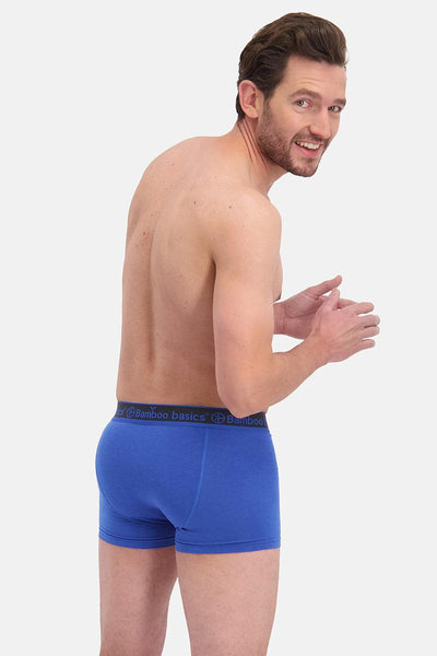 Man wearing blue boxer briefs on a white background