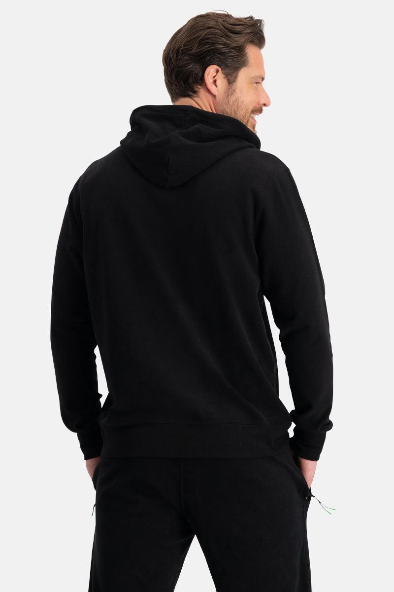 Man wearing a black organic cotton hoodie on a white background