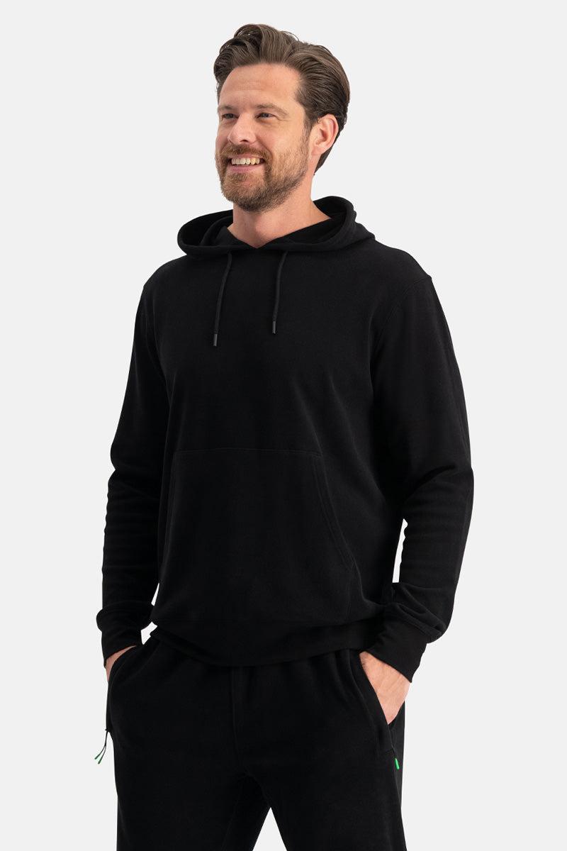 Man wearing a black bamboo hoodie and pants on a white background