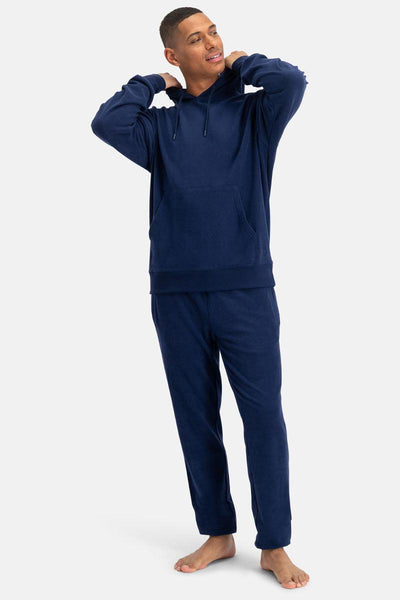 Man wearing a navy blue bamboo hoodie and pants on a white background