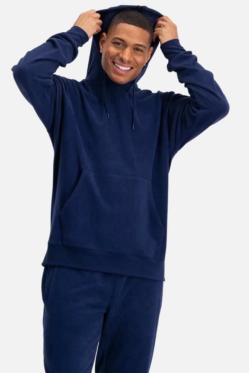 Man wearing a navy blue bamboo hoodie and pants on a white background
