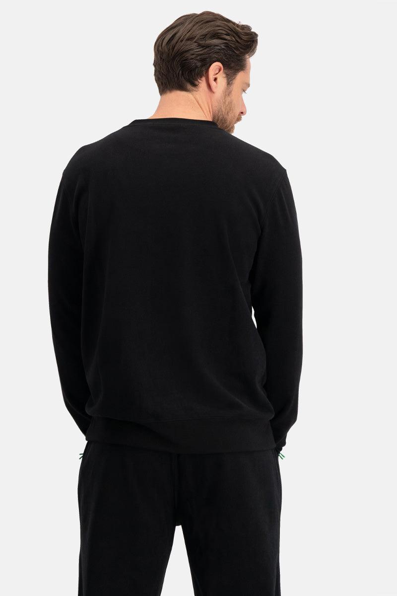 Man wearing a black long-sleeve bamboo shirt and pants on a white background