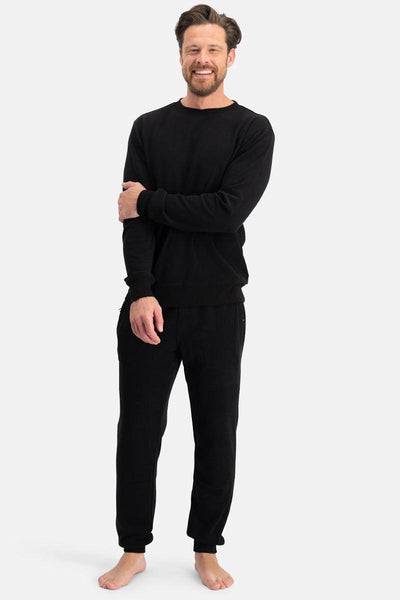 Man wearing a black long-sleeve bamboo basics sweatshirt and pants on a white background