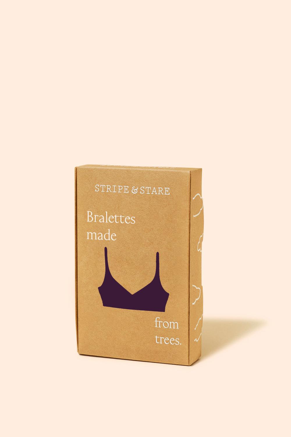Cardboard box with a purple bra illustration and text on a beige background