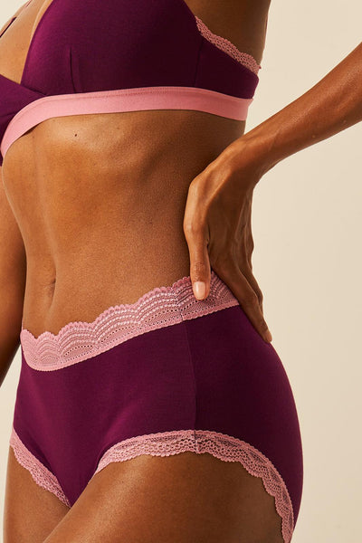 Purple lingerie set with pink lace trim on a beige background