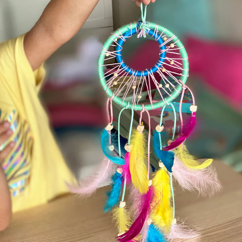 Colorful dreamcatcher held by a person with a blurred background