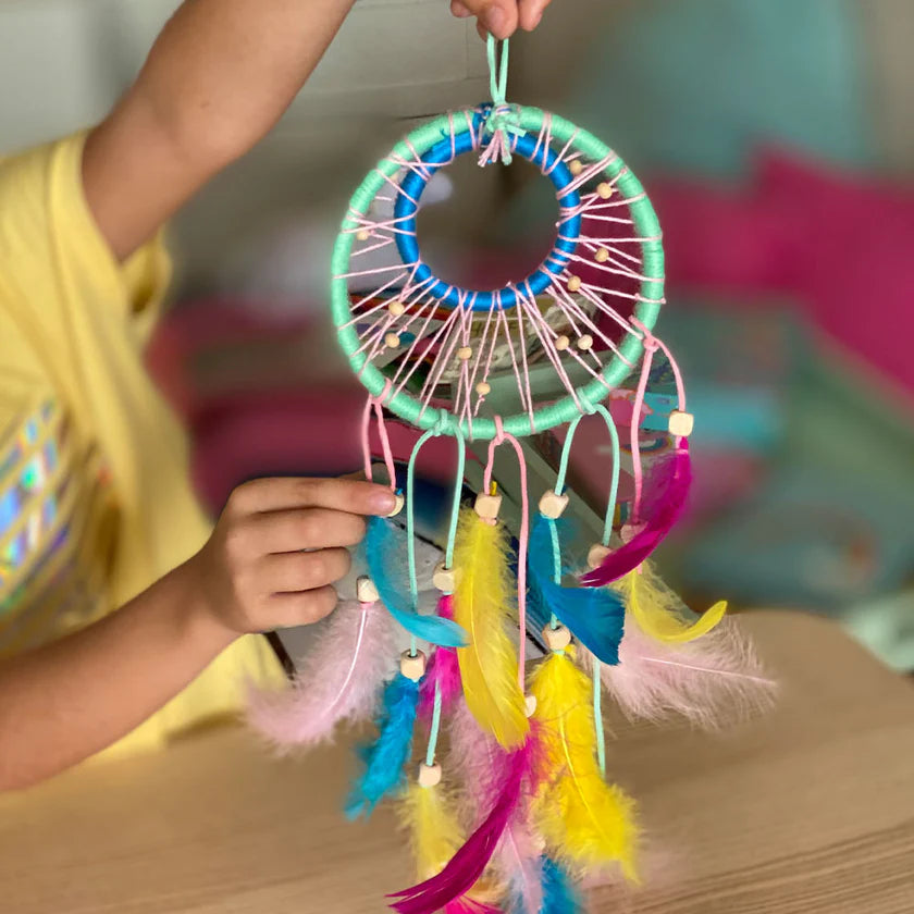 Colorful dreamcatcher held by a child with a blurred background