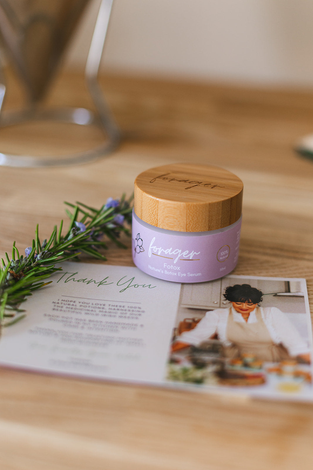 Purple jar with wooden lid on a table with a magazine and decorative elements