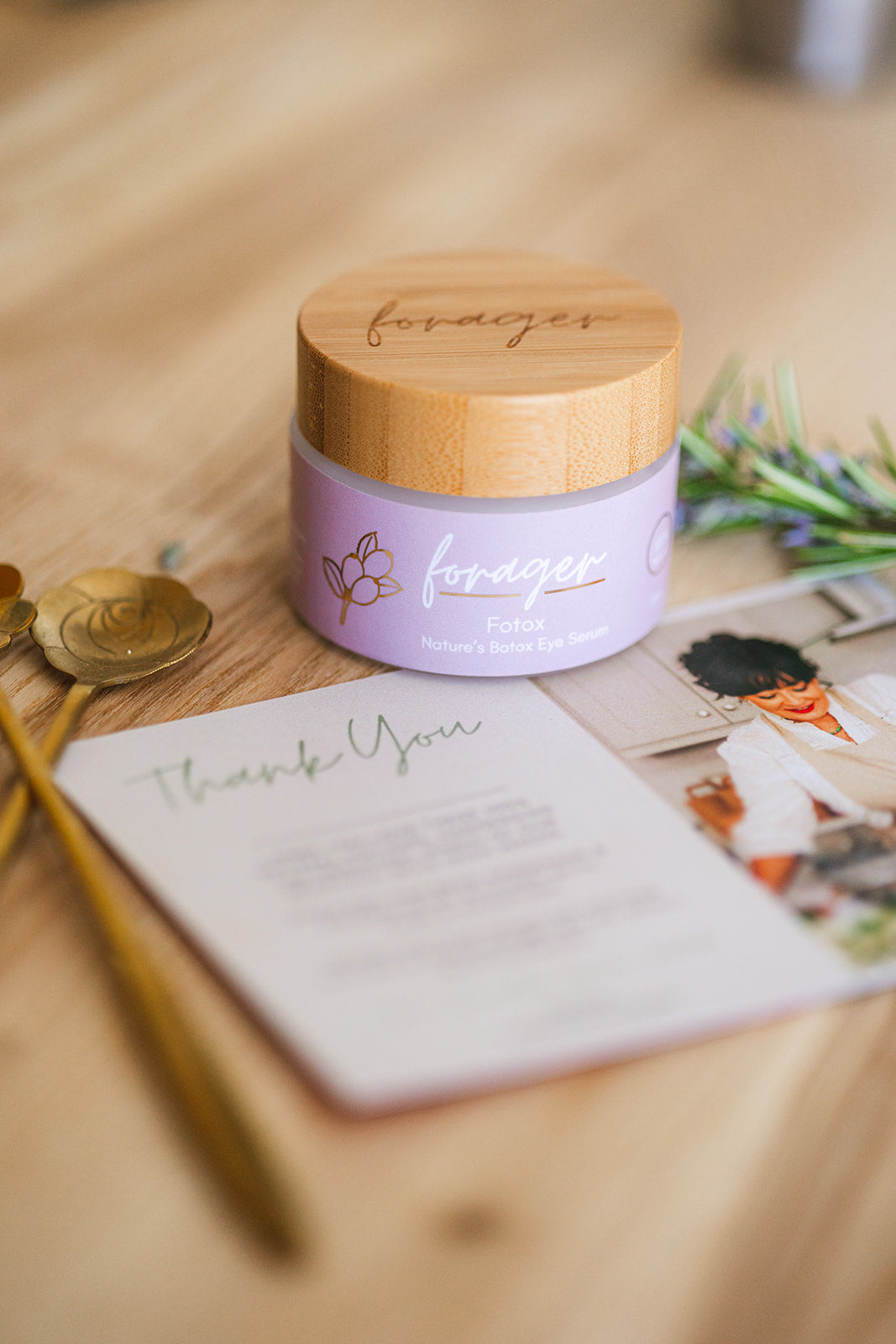 Purple jar with wooden lid on a wooden surface with a 'thank you' card and decorative elements.