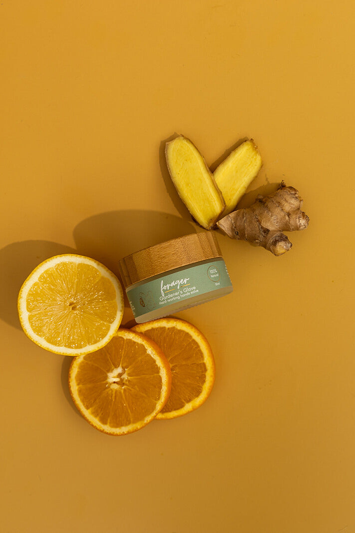 Jar of cream with sliced oranges and ginger on a yellow background