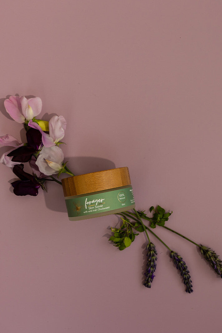 Jar of Lavageur body cream with flowers on a pink background