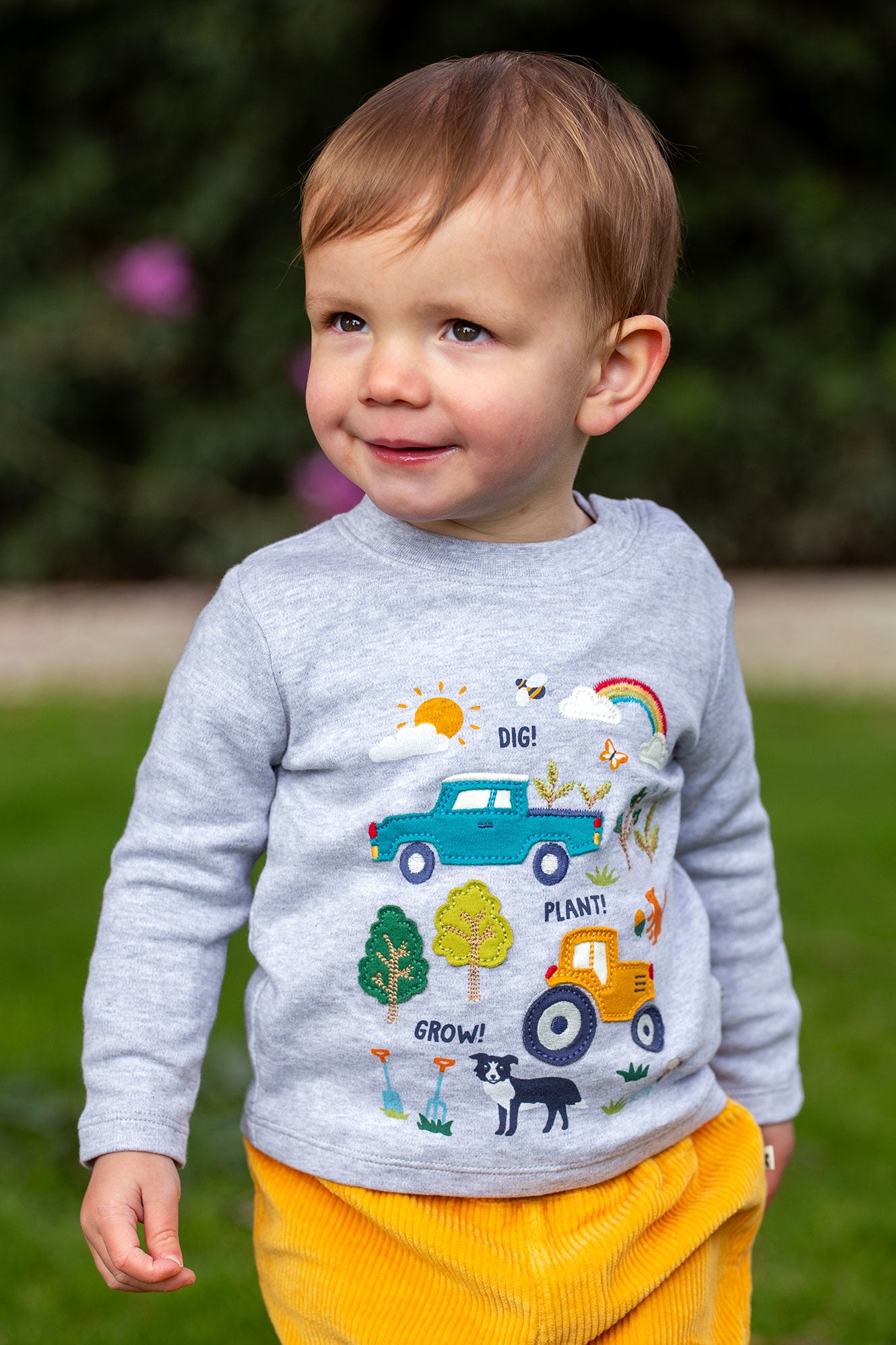 Toddler wearing grey organic cotton long sleeve top with farm design 
