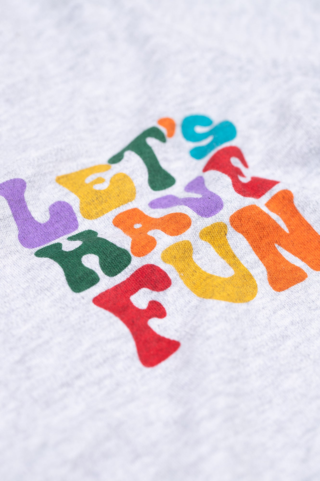 Colourful text 'LET'S HAVE FUN' on a kids organic cotton top