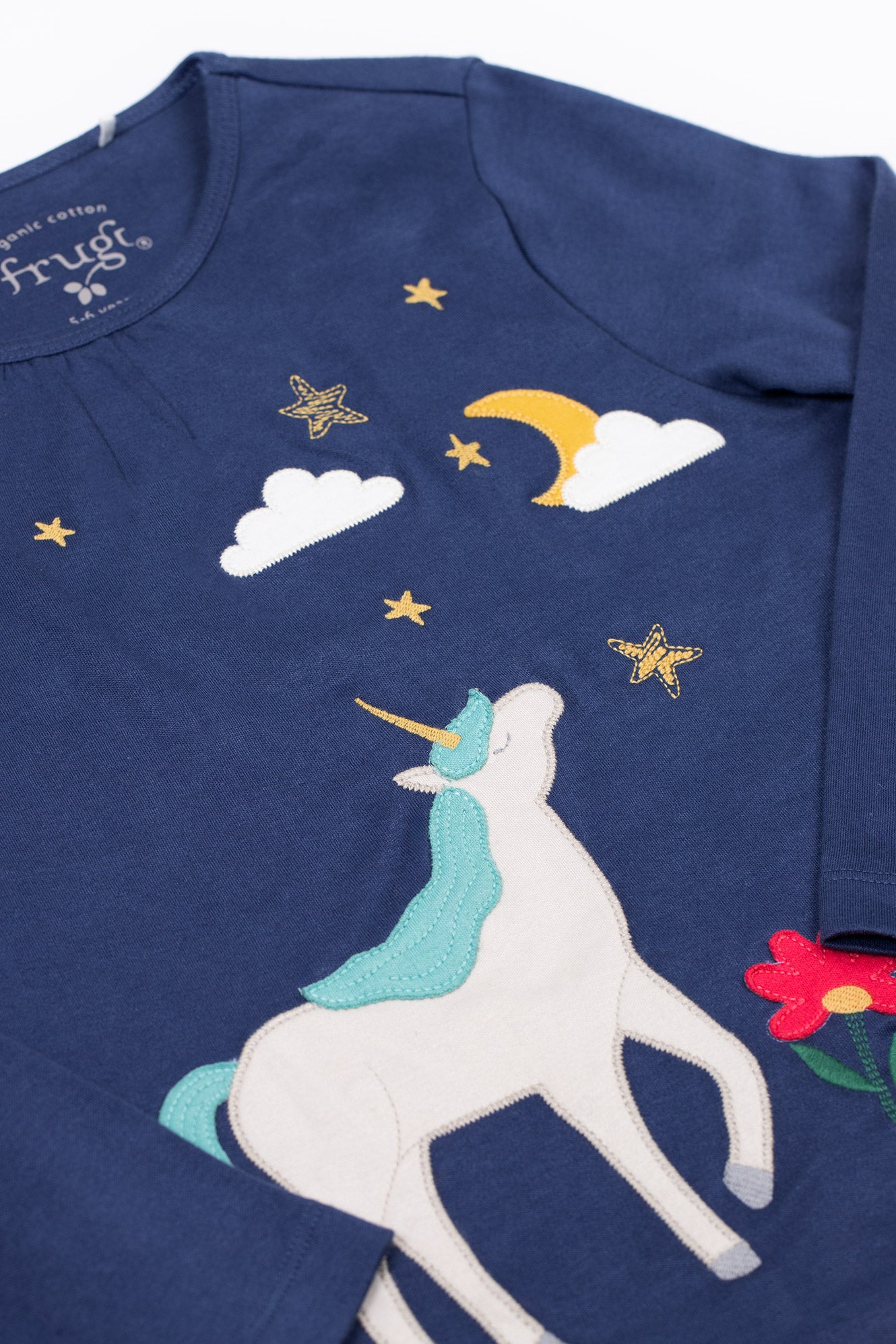 Navy organic cotton top with unicorn, stars, and clouds design on a white background