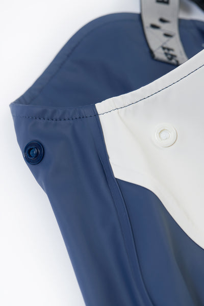 Close-up of blue and white overalls with buttons on a white background