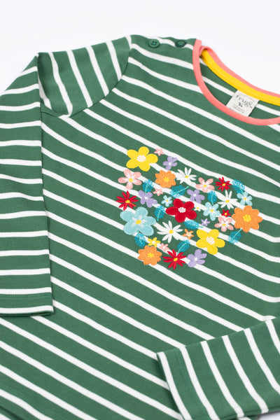 Close up of folded sleeves and flower appliqués and embroidery detailing on GOTS organic cotton top