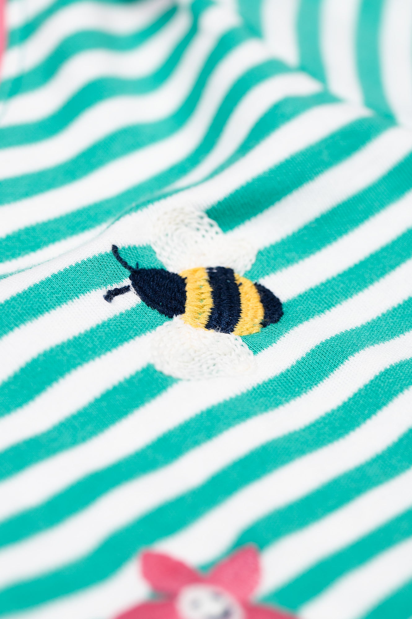 Detailed bee appliqué on Frugi Orion striped organic cotton top, made with GOTS certified cotton