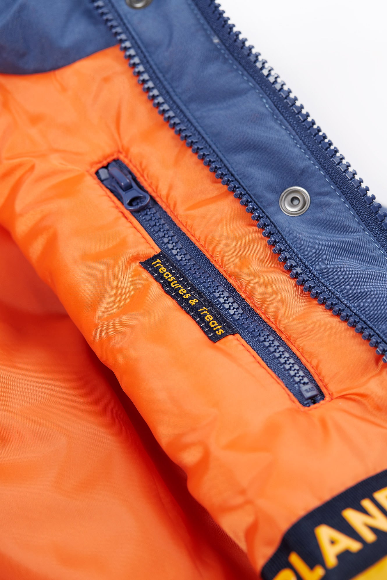 Close-up of orange and blue jacket with zipper and brand logo.