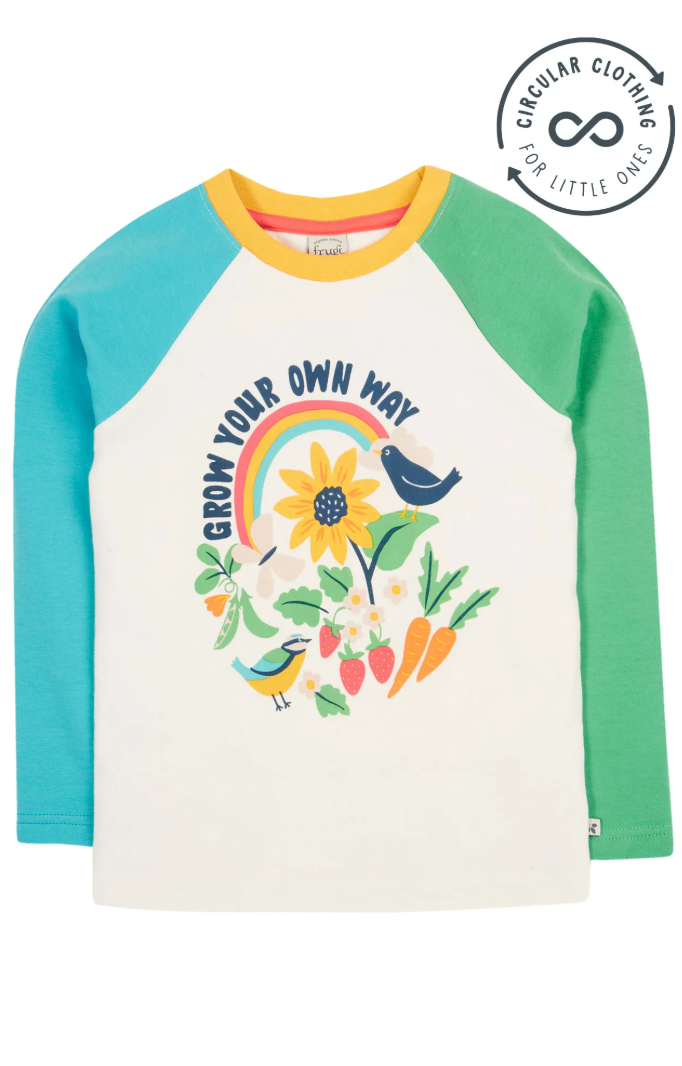 White long-sleeved raglan top with contrasting teal and green sleeves, featuring a colourful 'GROW YOUR OWN WAY' graphic with a rainbow, sunflower, and various vegetables.