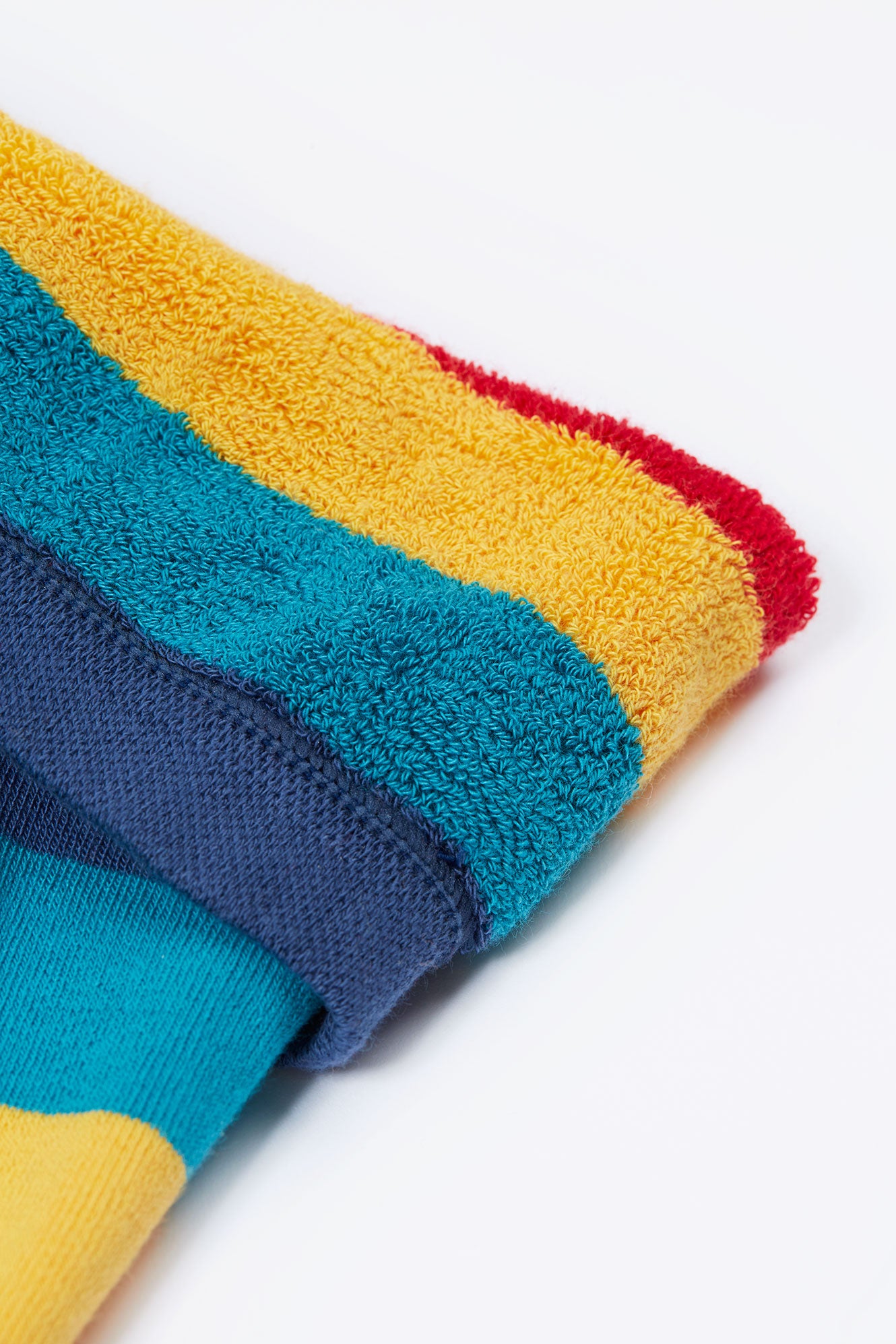 Colorful folded tights with blue, yellow, and red sections on a white background