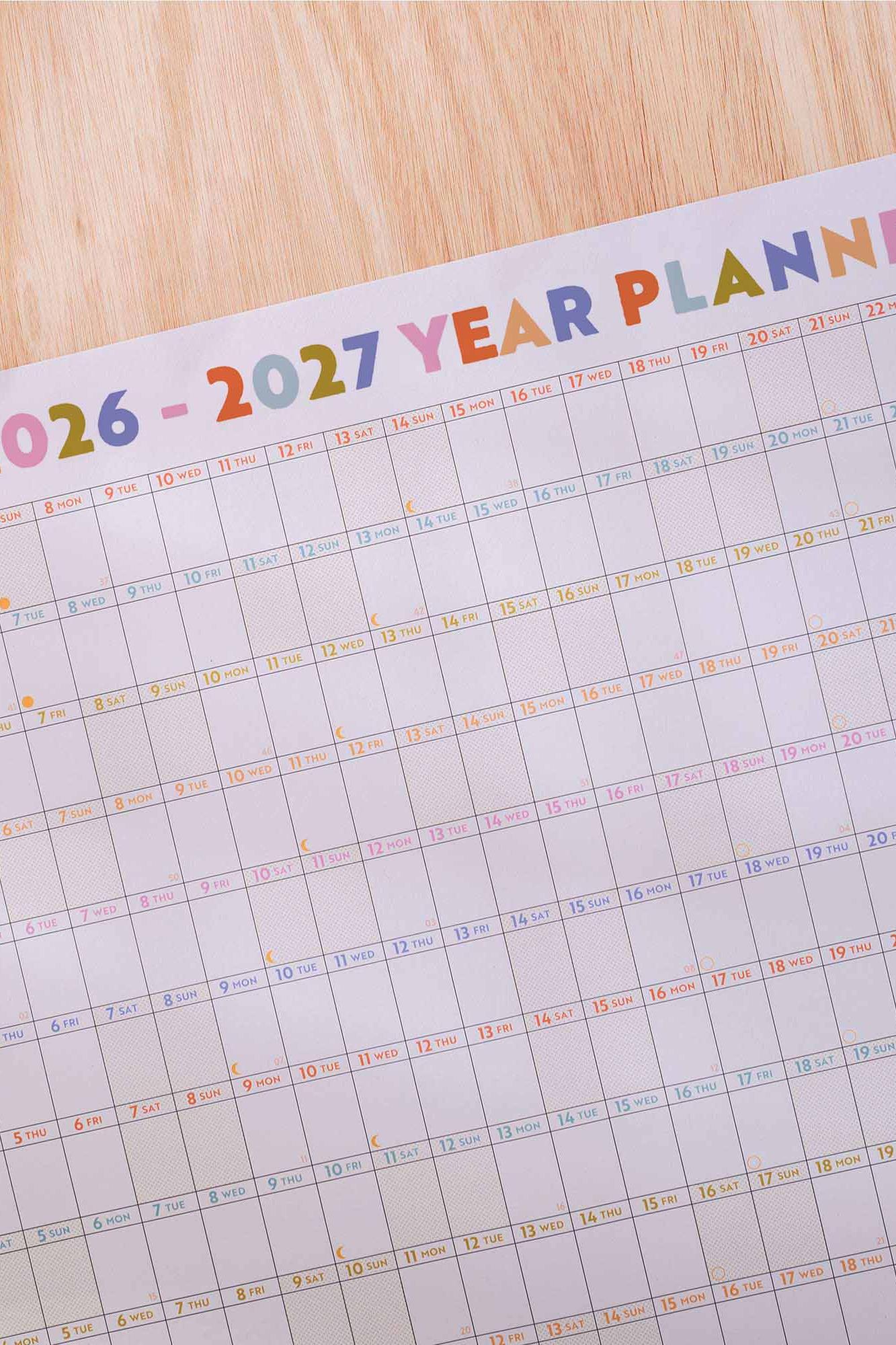 Yearly planner from 2026 to 2027 on a wooden surface