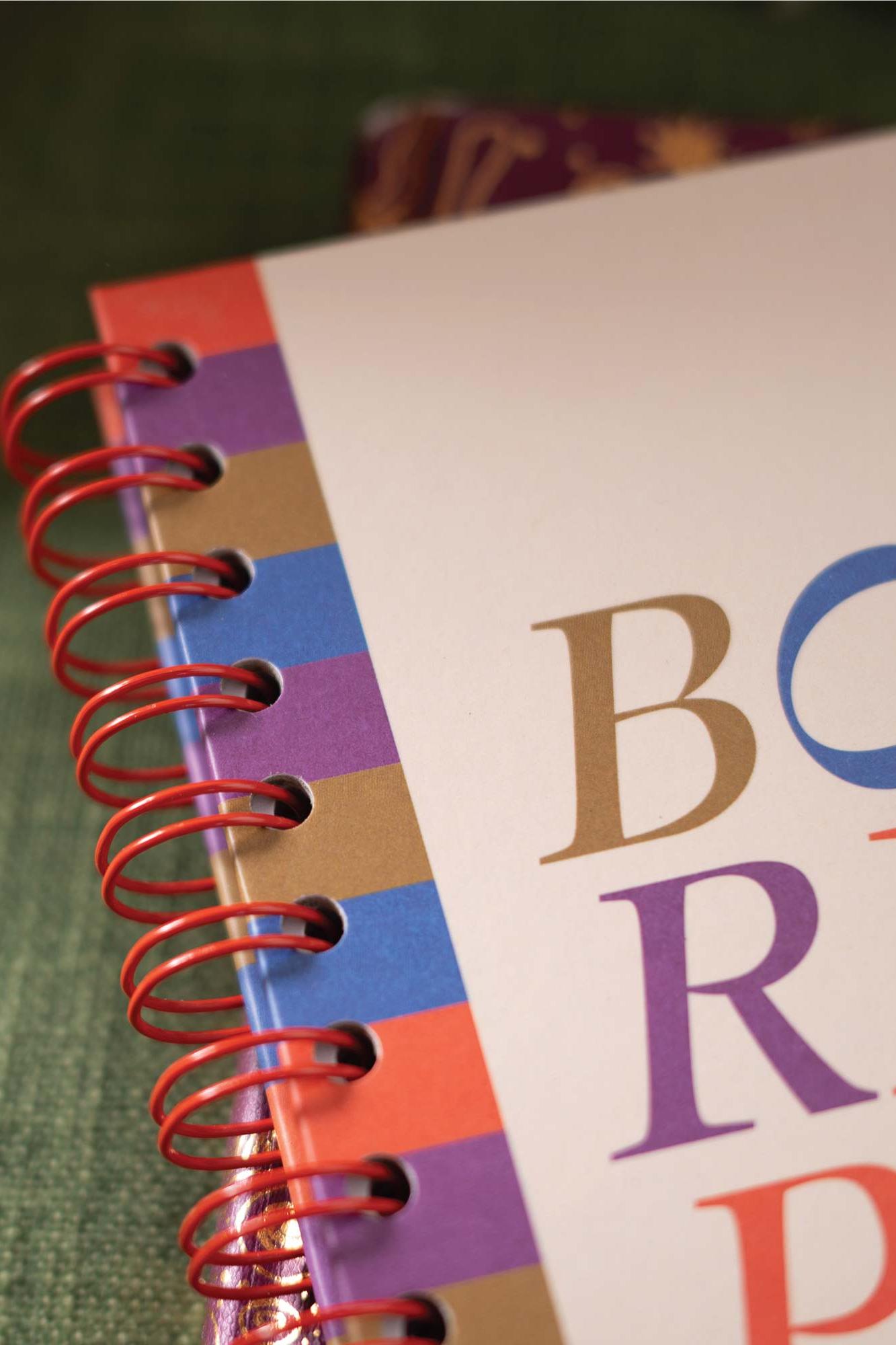 Colorful spiral-bound notebook with a colorful cover and letters on the cover.