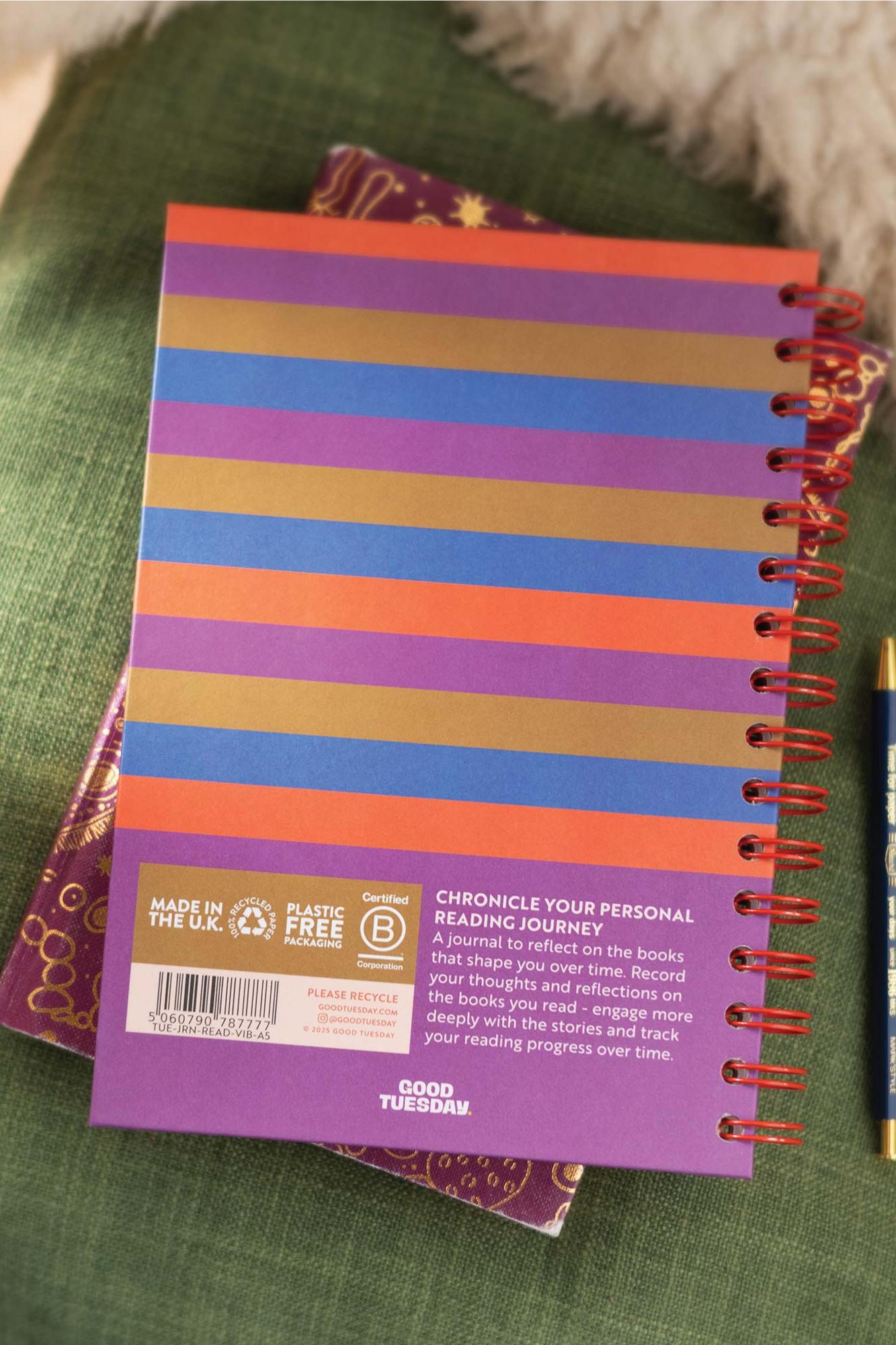 Colorful spiral-bound notebook with a brown label on a green surface