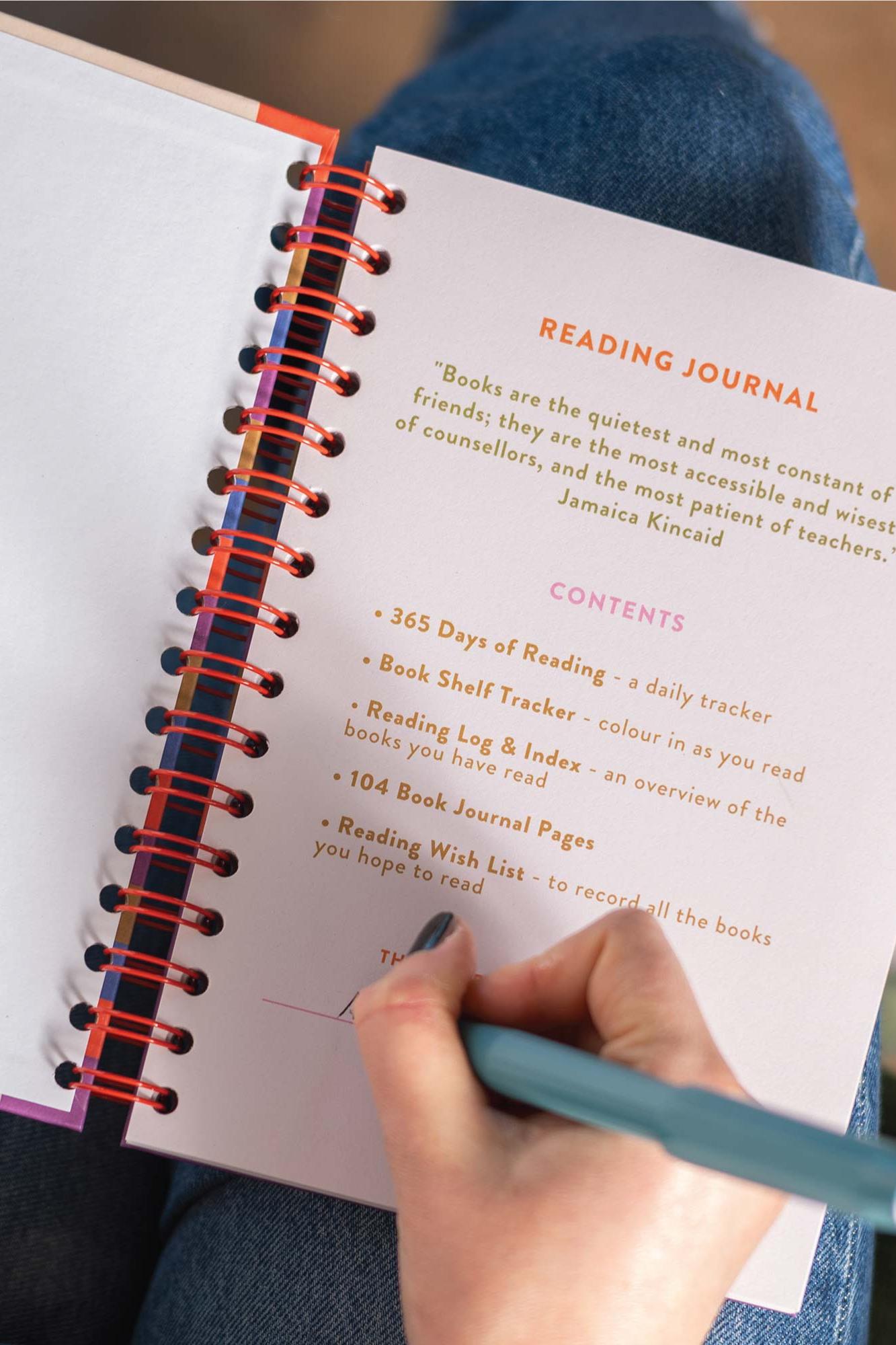Reading journal with a hand holding a pen, open to the contents page.