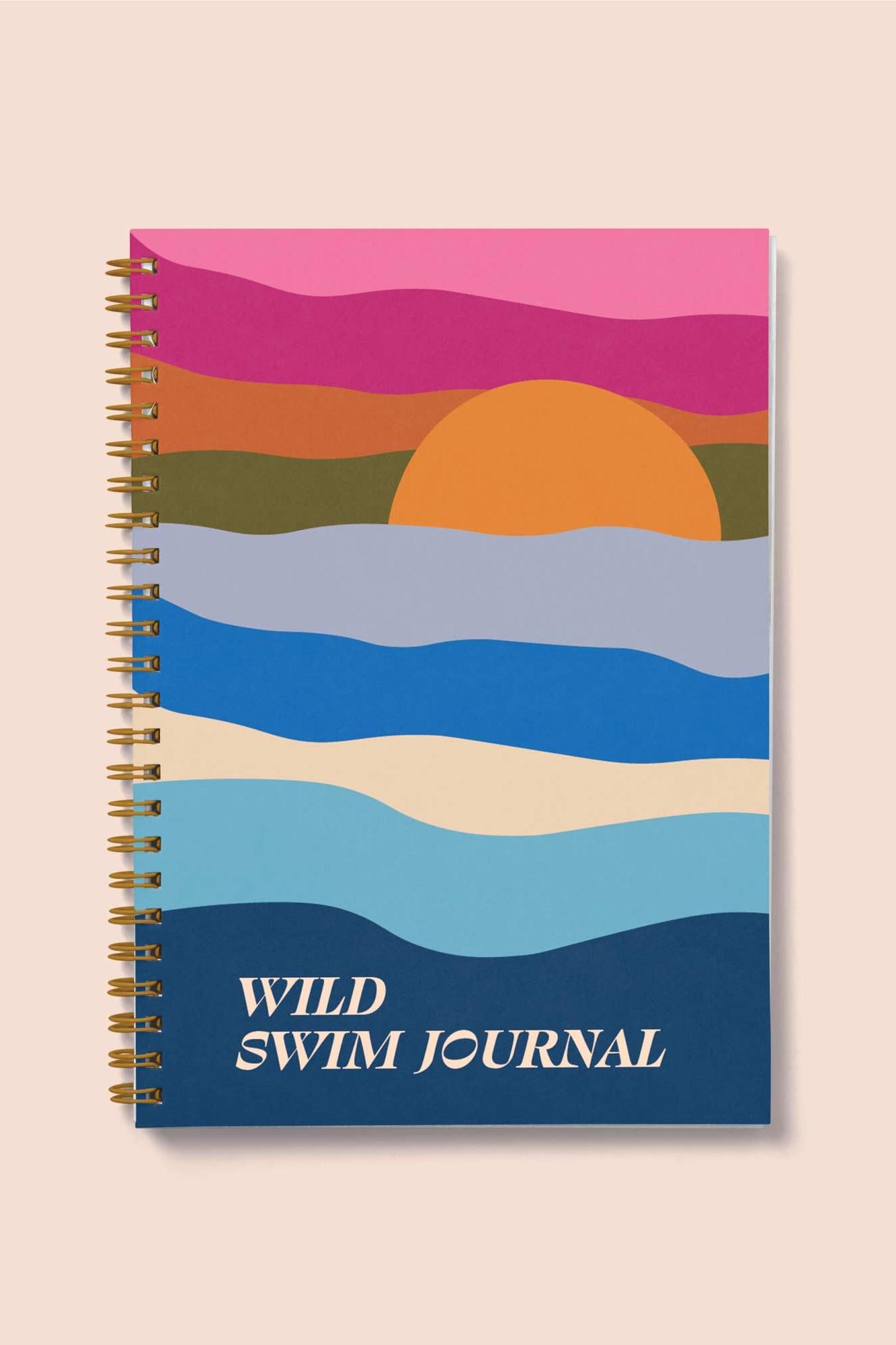 Spiral-bound notebook with a colorful sunset design on the cover, titled 'Wild Swim Journal'.