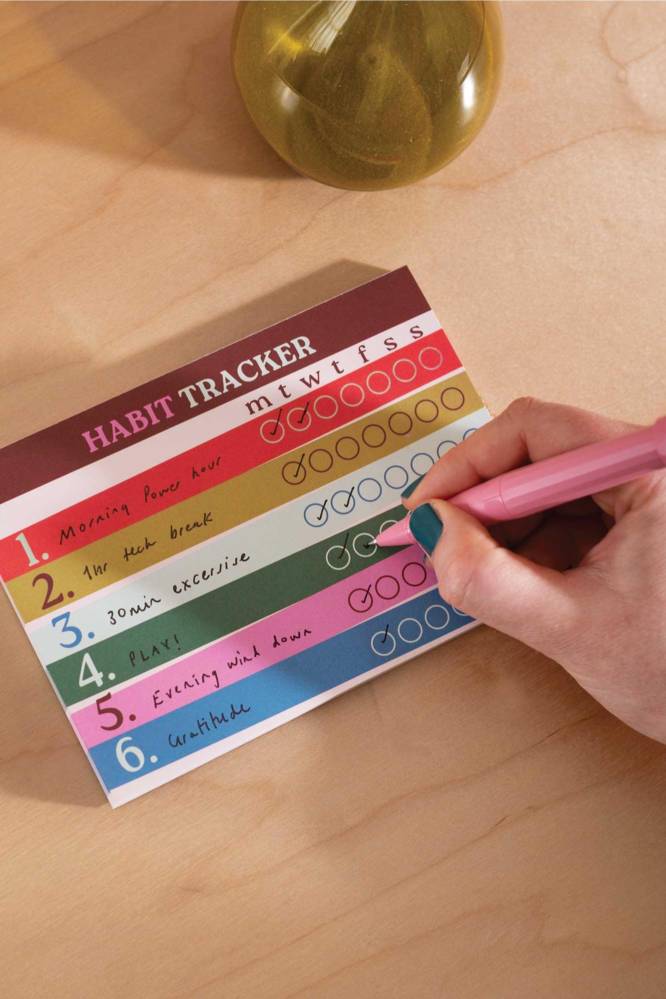 Habit tracker with colourful design on a wooden surface