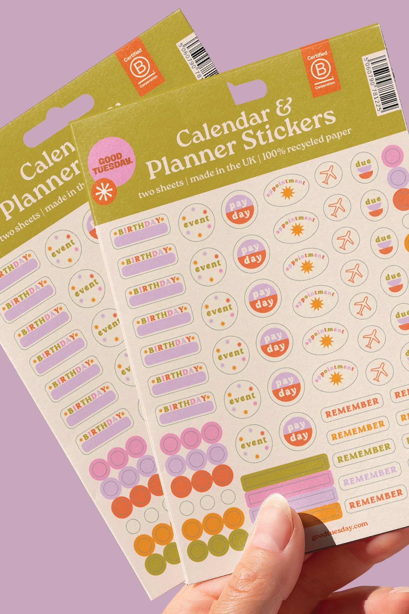 Calendar and planner stickers with colourful designs held by a hand on a purple background