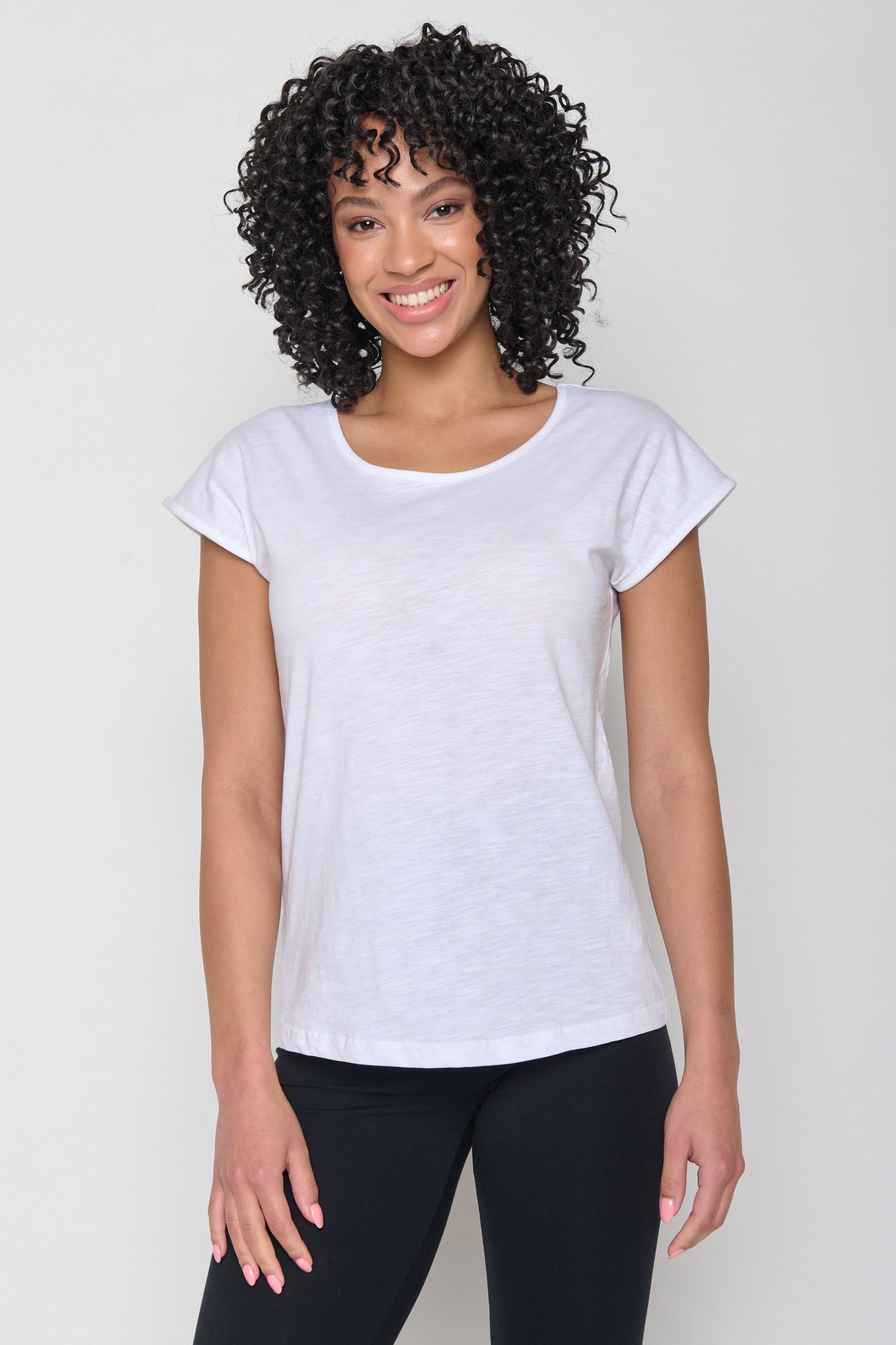 Woman wearing a white Greenbomb Basic Cool GOTS T-shirt made from organic cotton, standing against a white background.