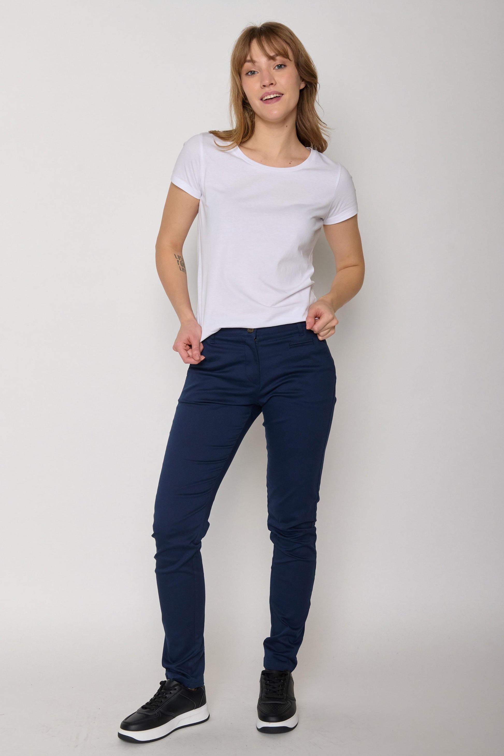 Model wearing organic cotton plain white tee paired with navy trousers and black trainers