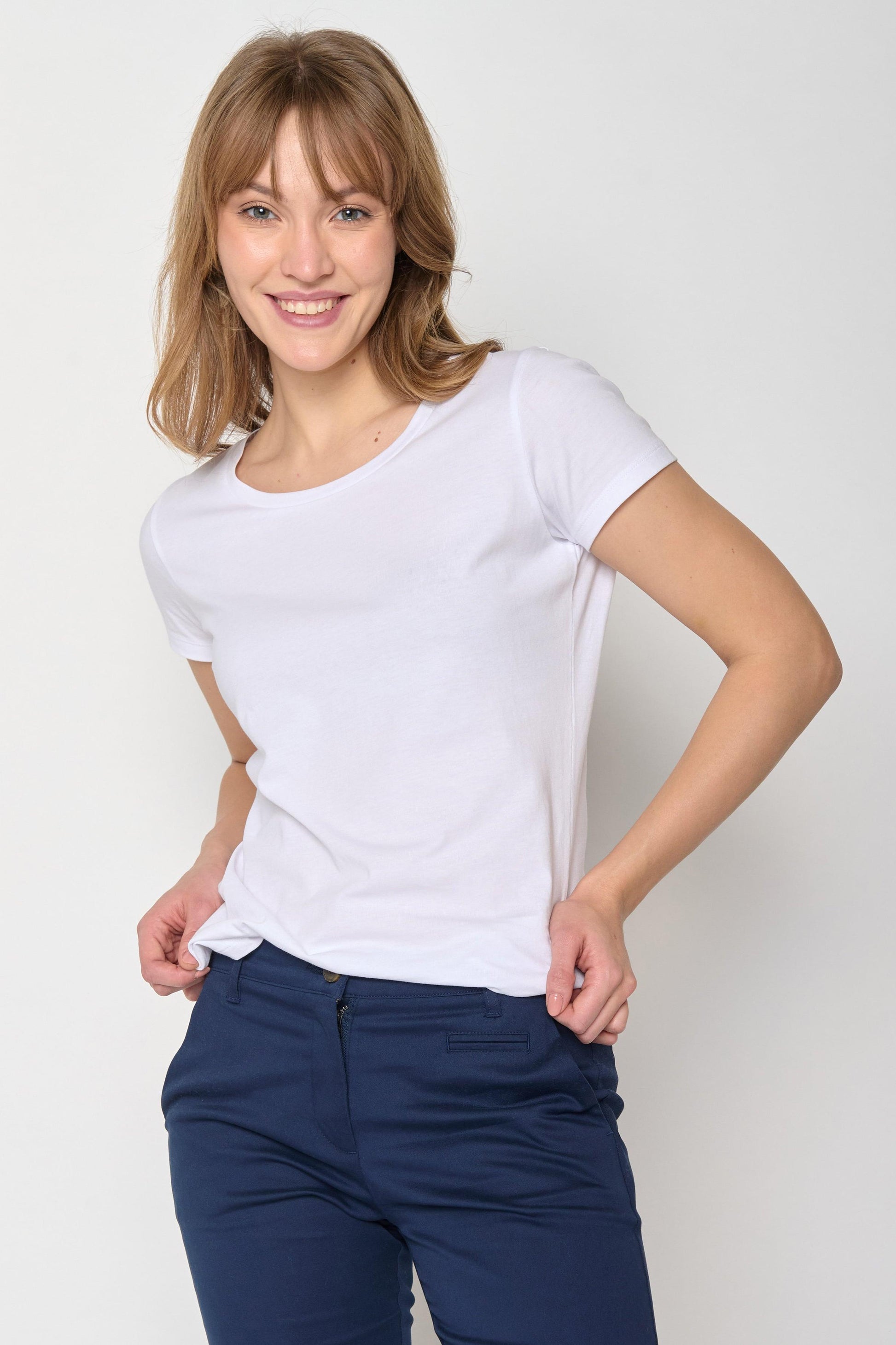 Model wearing plain white t-shirt with navy trousers