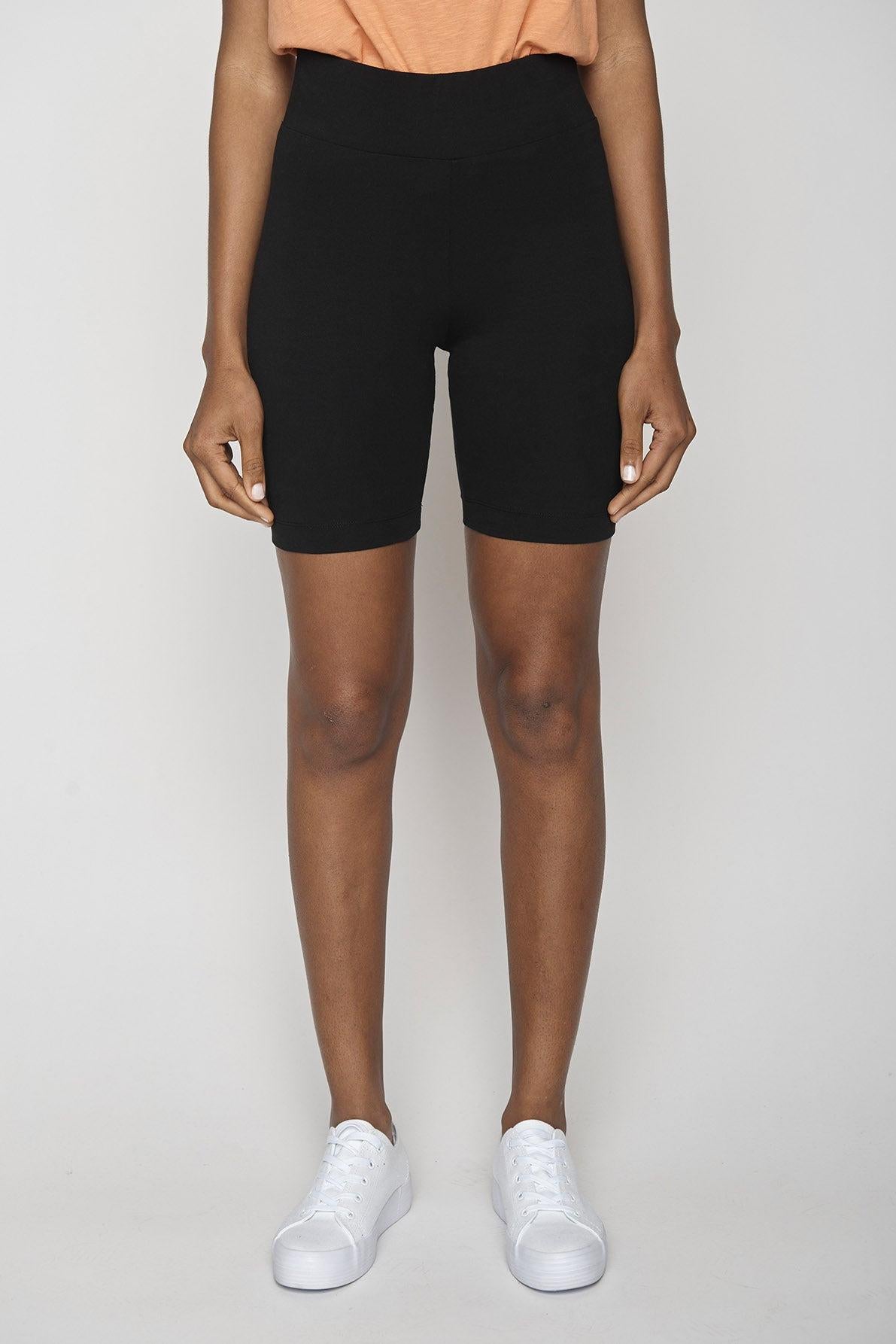 Model wearing bicycle shorts with white trainers