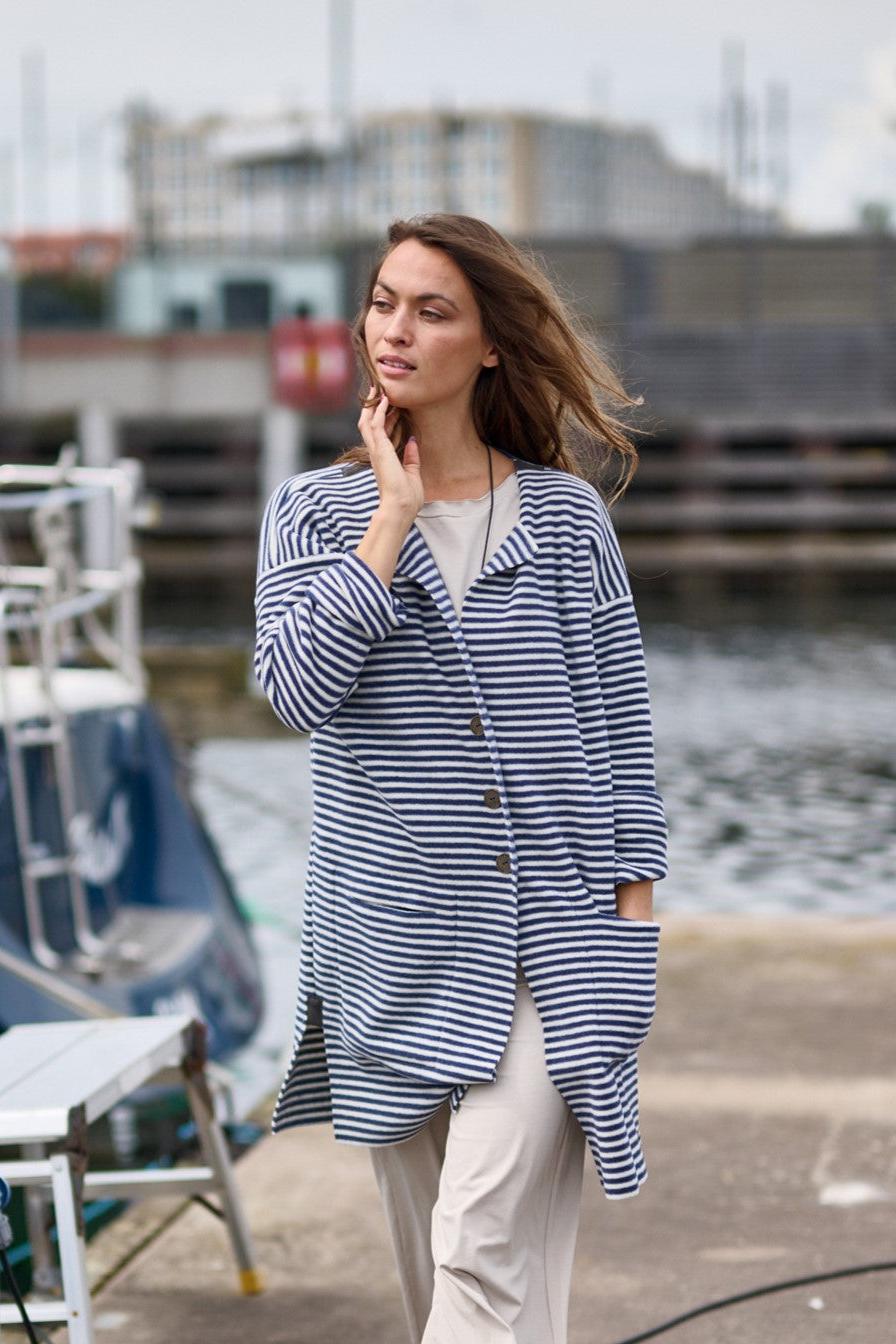 Model wearing henriette steffensen cardigan in an outdoor setting layered casually.