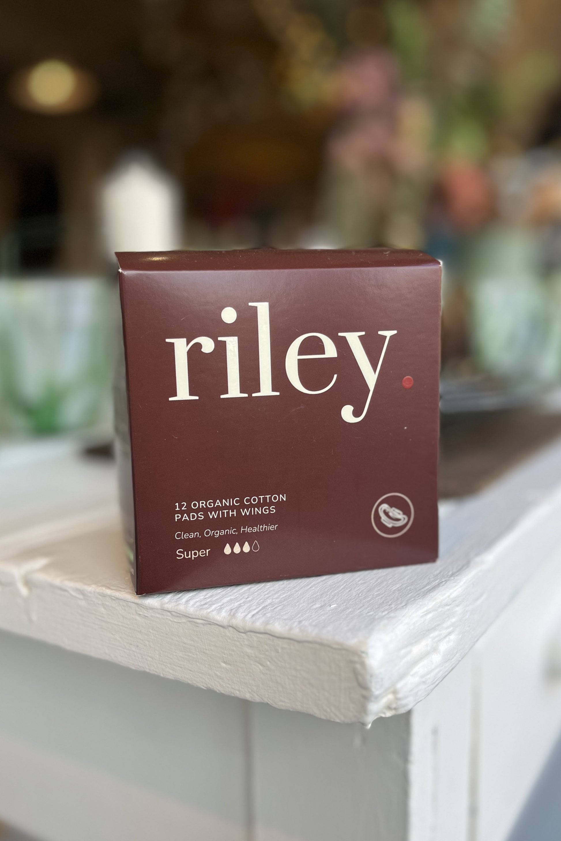 Box of Riley organic cotton pads on a surface with a blurred background