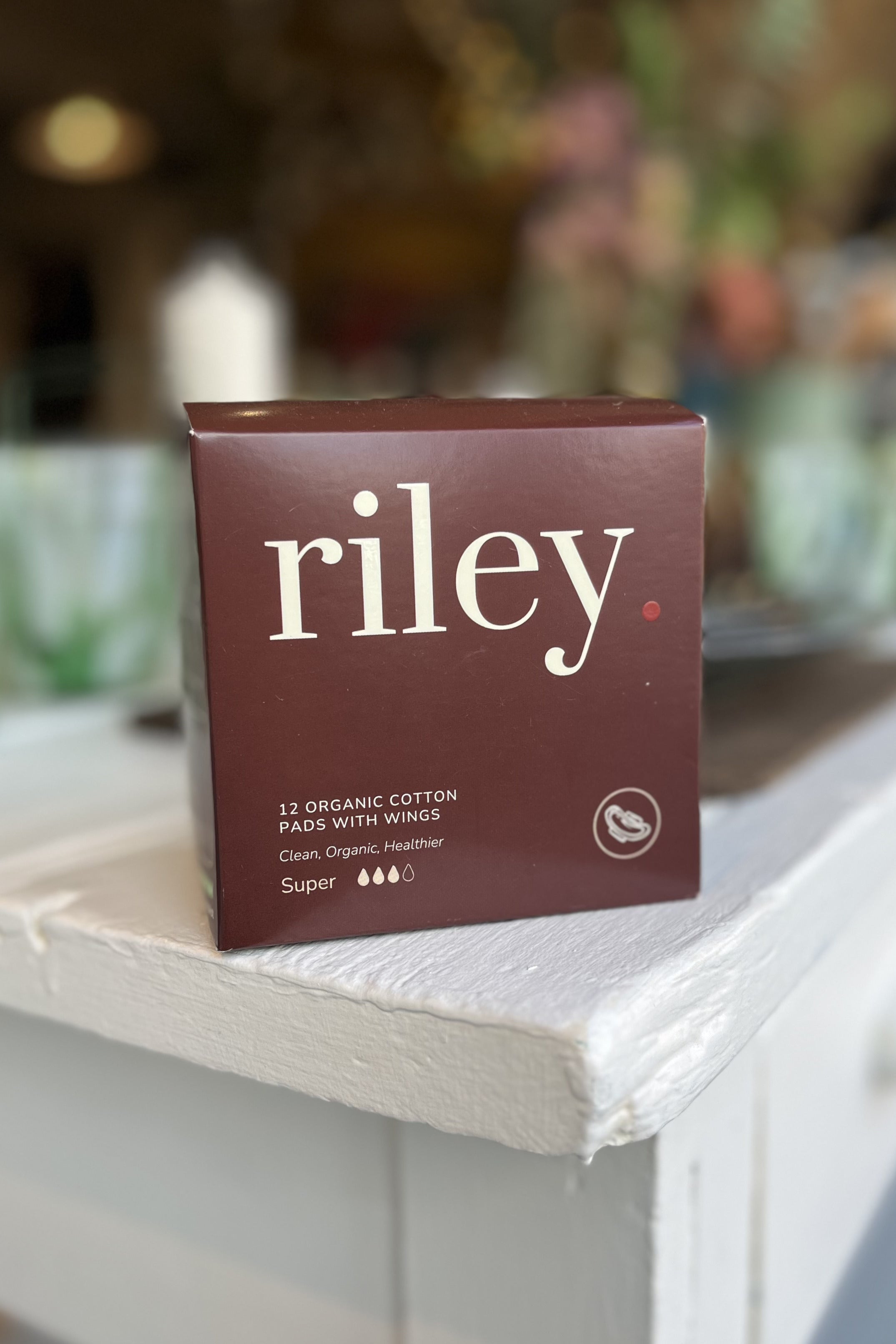 Box of Riley organic cotton pads on a surface with a blurred background